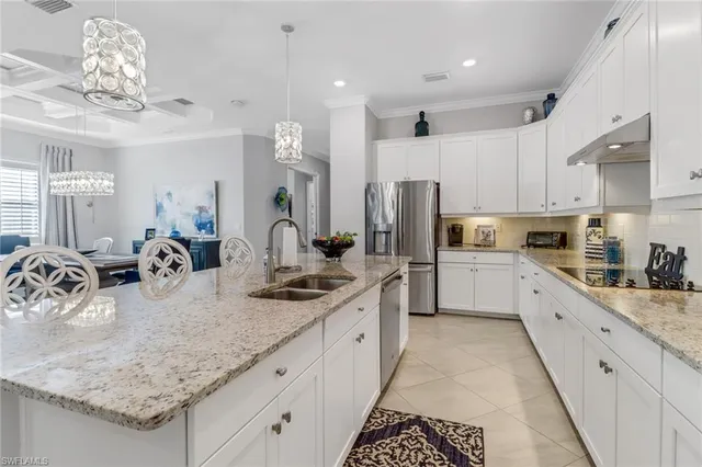 a kitchen with stainless steel appliances granite countertop a sink refrigerator and cabinets
