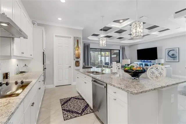 a kitchen with kitchen island granite countertop a sink and a stove top oven with wooden floor