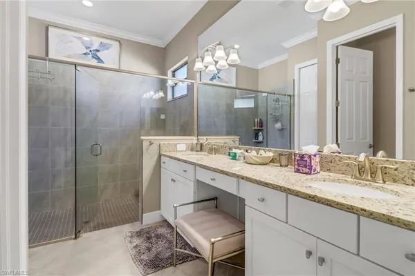 a bathroom with a double vanity sink mirror and shower