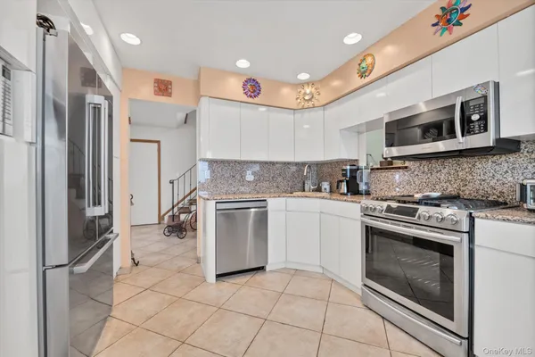 a kitchen with stainless steel appliances granite countertop a stove a sink and a refrigerator
