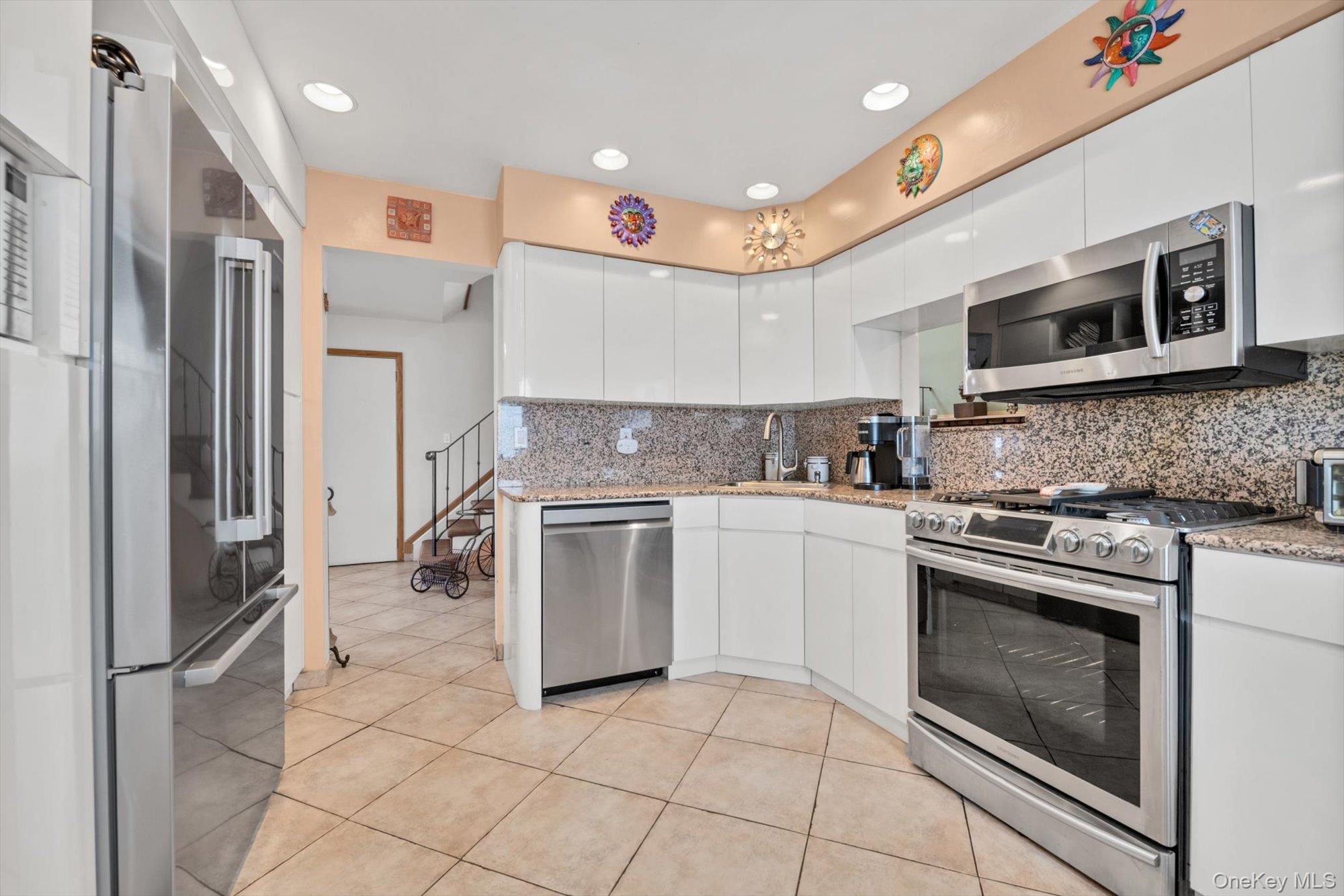 713 Hungry Harbor Road Valley Stream, NY 11581 - Photo 5 of 25 a kitchen with stainless steel appliances granite countertop a stove a sink and a refrigerator