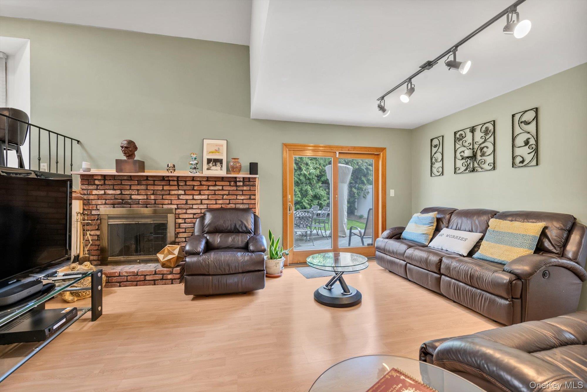 713 Hungry Harbor Road Valley Stream, NY 11581 - Photo 10 of 25 a living room with furniture a flat screen tv and a fireplace
