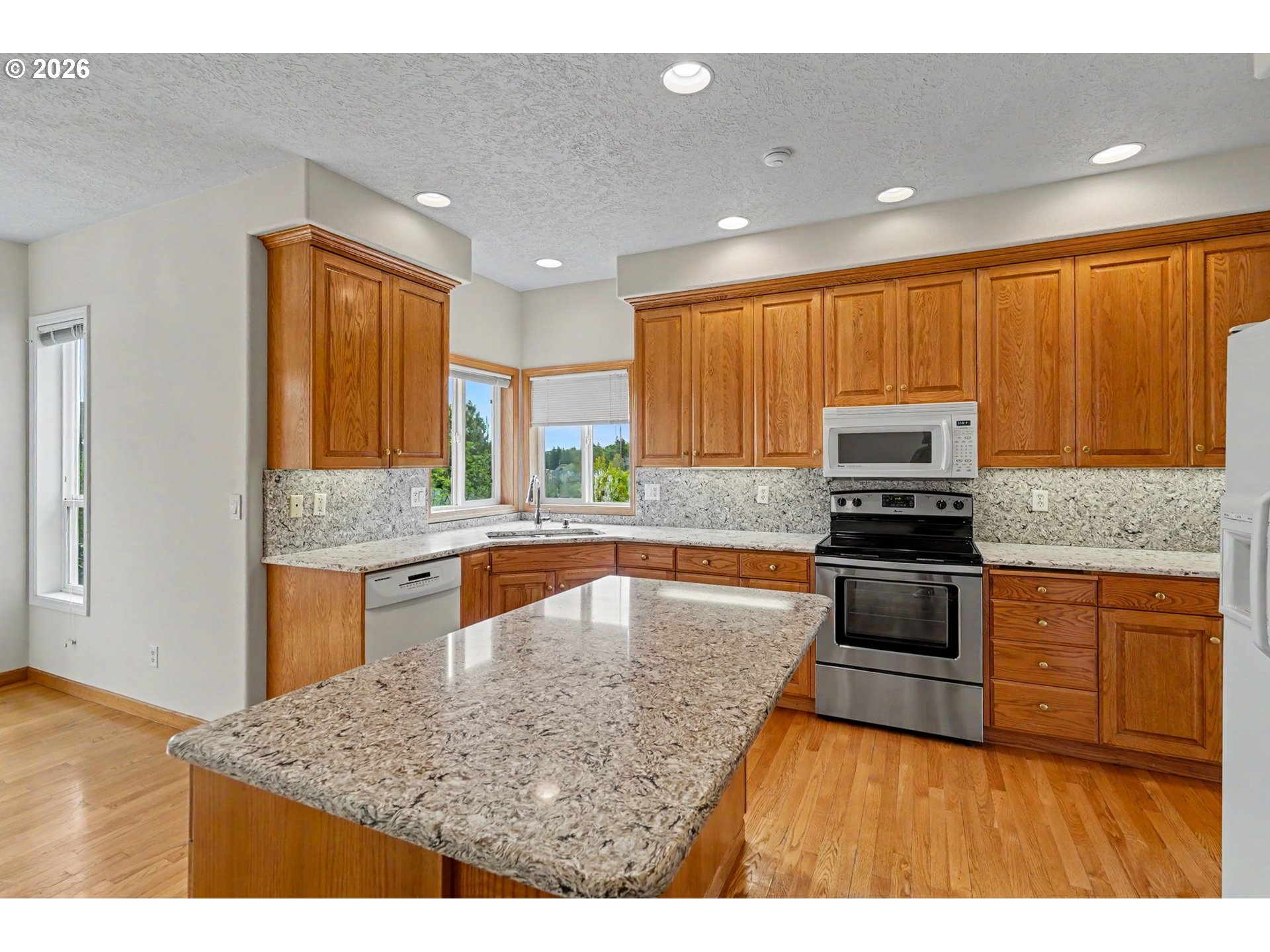 1470 Ranier Loop Northwest Salem, OR 97304 - Photo 15 of 48 a kitchen with stainless steel appliances granite countertop wooden cabinets a granite counter and a sink