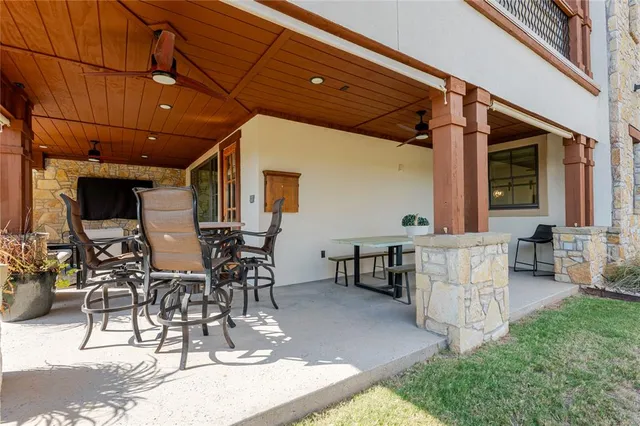 a view of a patio with table and chairs with wooden floor and fence