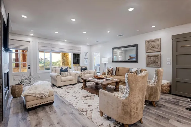 a living room with furniture wooden floor and a large window