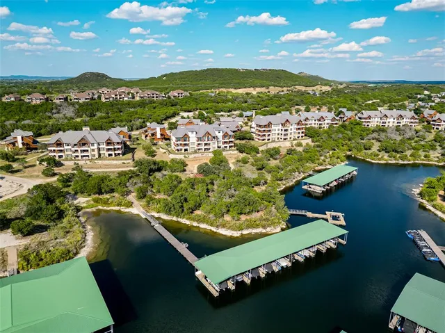 an aerial view of a city with lots of residential buildings and mountain view in back