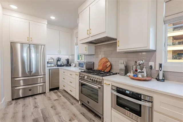 a kitchen with stainless steel appliances granite countertop a refrigerator stove and sink