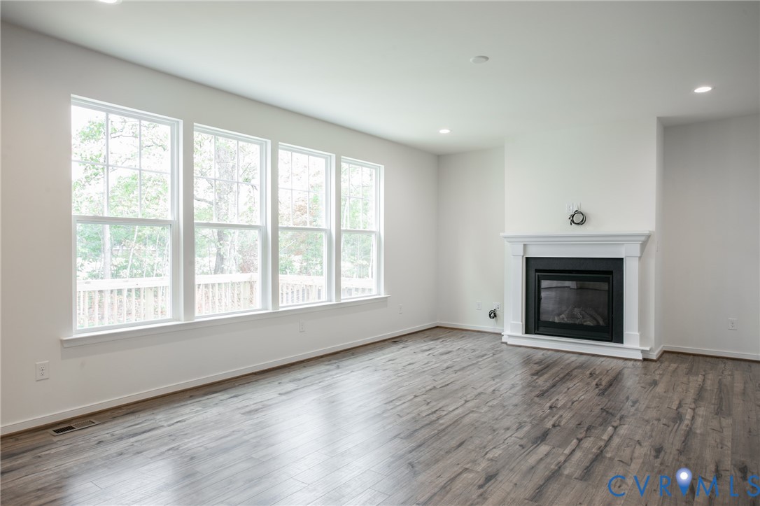 4830 Tuscany Road Moseley, VA 23120 - Photo 8 of 23 an empty room with wooden floor fireplace and windows