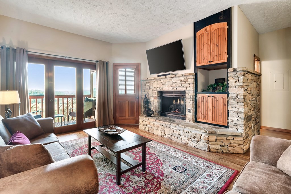 2044 Hickory Ridge Way, Unit 334 Sevierville, TN 37862 - Photo 10 of 28 a living room with furniture a fireplace and a flat screen tv