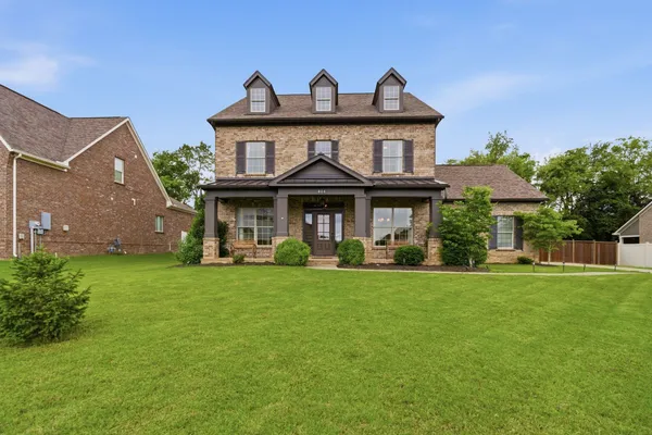 a front view of a house with a garden and porch