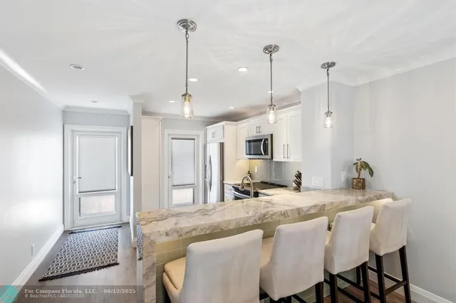 a living room with furniture a chandelier and a dining table