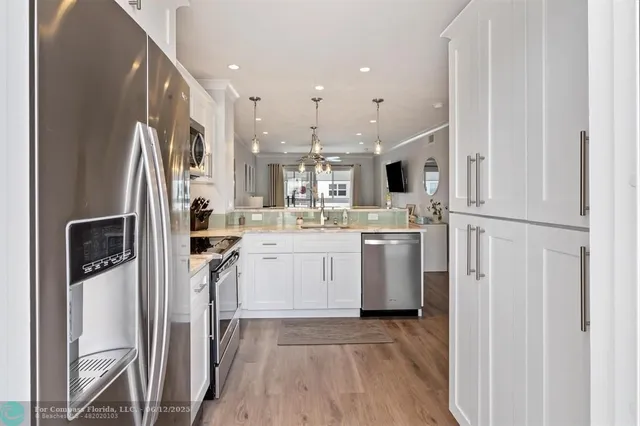 a dining room with furniture a chandelier and wooden floor