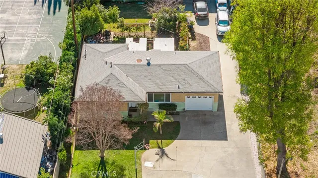an aerial view of a house with a yard and potted plants