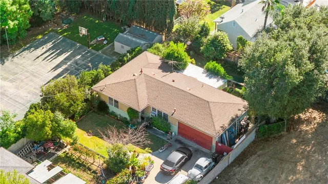 an aerial view of a house with yard and swimming pool