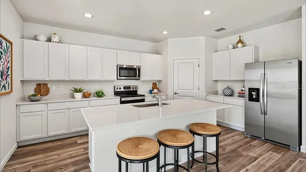 a kitchen with stainless steel appliances a refrigerator stove microwave and cabinets