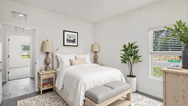 a bedroom with a bed and a potted plant on the dresser