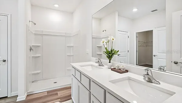 a bathroom with a shower sink and mirror