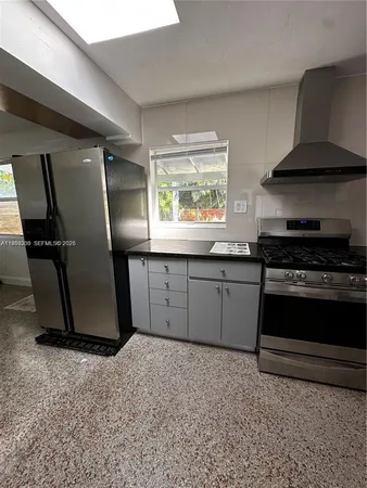 a kitchen with granite countertop a stove and a refrigerator