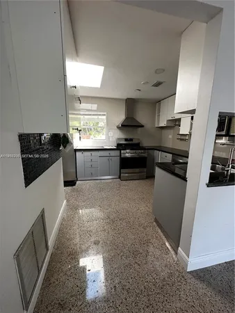 a kitchen with stainless steel appliances granite countertop a stove a sink a refrigerator a counter space and cabinets