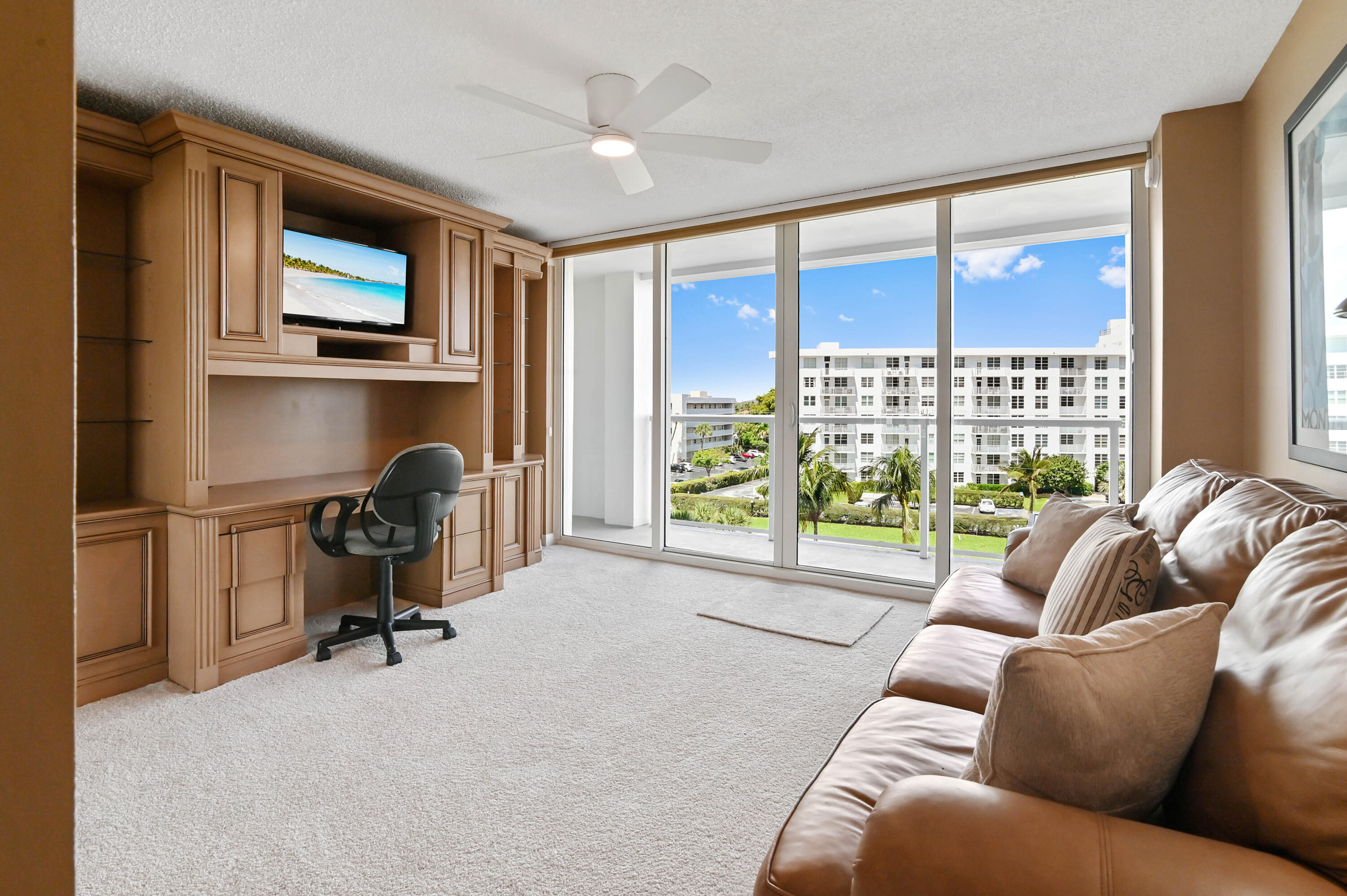 2800 South Ocean Boulevard, Unit 5J Boca Raton, FL 33432 - Photo 21 of 56 a living room with furniture a floor to ceiling window and a flat screen tv