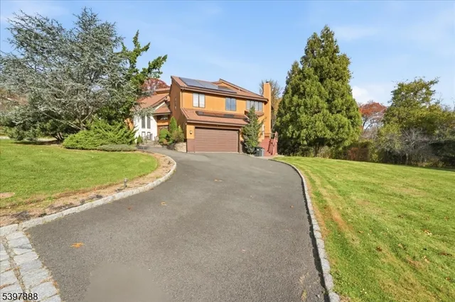 a view of a house with a yard and basketball court