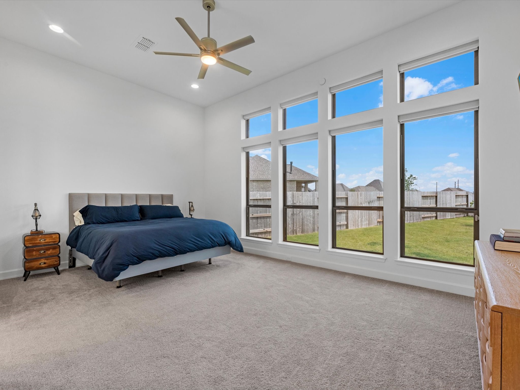 18714 Pistachio Way Manvel, TX 77578 - Photo 18 of 48 The private primary suite is a true retreat, featuring soaring 12-foot ceilings, abundant natural light, reflective solar window film, and motorized solar shades for enhanced comfort, energy efficiency, and privacy.