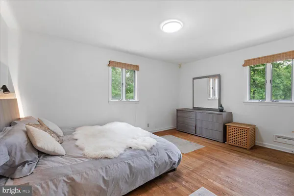 a bedroom with a bed dresser and a window