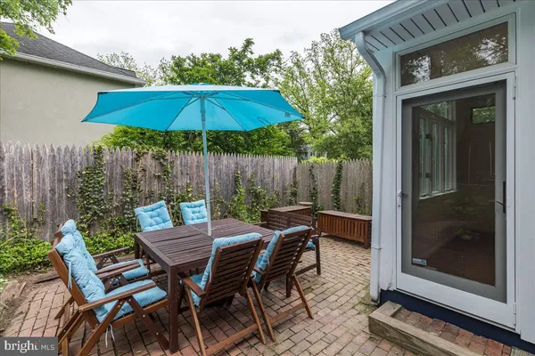 a view of backyard with seating space and wooden fence