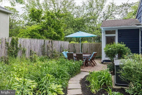 a view of backyard with table and chairs under an umbrella