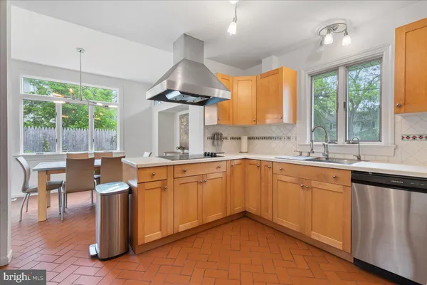 a kitchen with stainless steel appliances granite countertop a sink a stove and a refrigerator