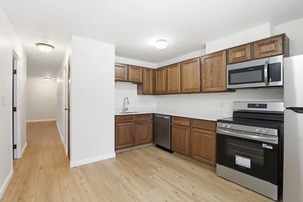 a kitchen with stainless steel appliances granite countertop a stove a sink and a microwave