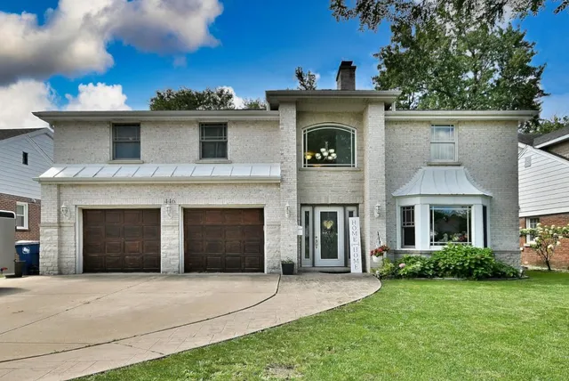 a front view of a house with a garden and yard