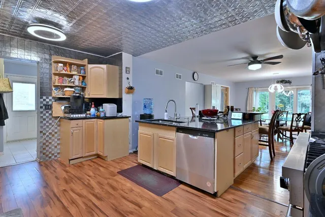 a kitchen with stainless steel appliances granite countertop a stove and a wooden floors