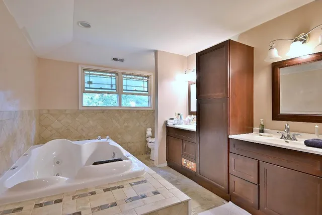 a bathroom with a tub sink and mirror
