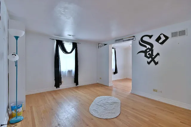 a view of a livingroom with wooden floor and a ceiling fan