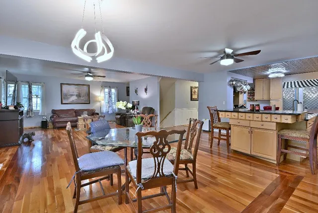 a view of a dining room with furniture a chandelier and wooden floor