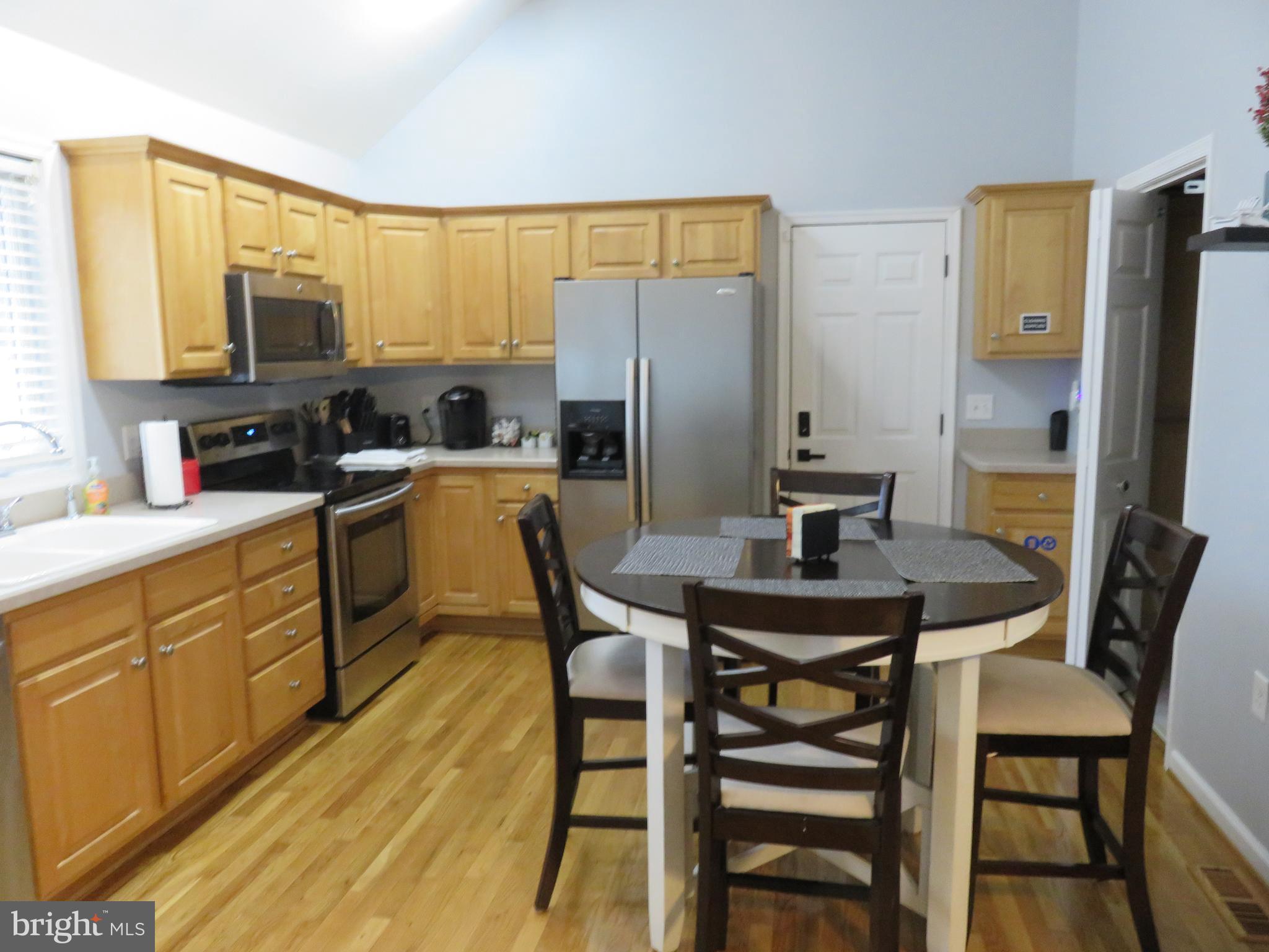 28 Bryan Drive Rehoboth Beach, DE 19971 - Photo 13 of 41 a kitchen with a table chairs refrigerator and microwave