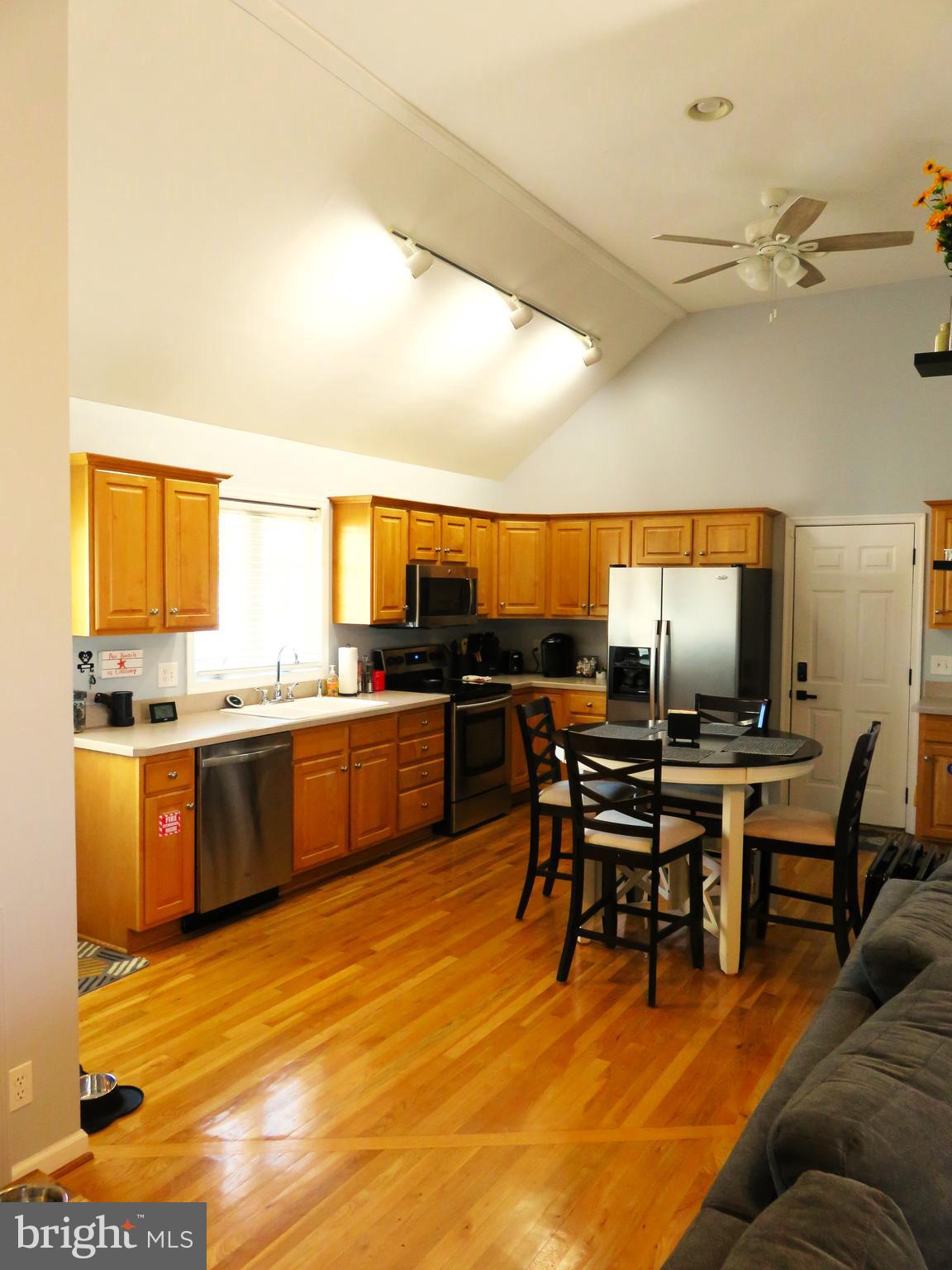 28 Bryan Drive Rehoboth Beach, DE 19971 - Photo 14 of 41 a kitchen with stainless steel appliances kitchen island granite countertop a sink table and chairs