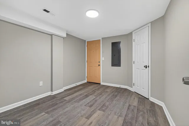a view of an empty room with wooden floor