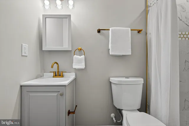 a bathroom with a toilet sink and mirror