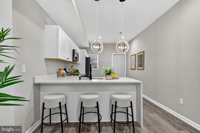 a kitchen with stainless steel appliances a table and chairs in it