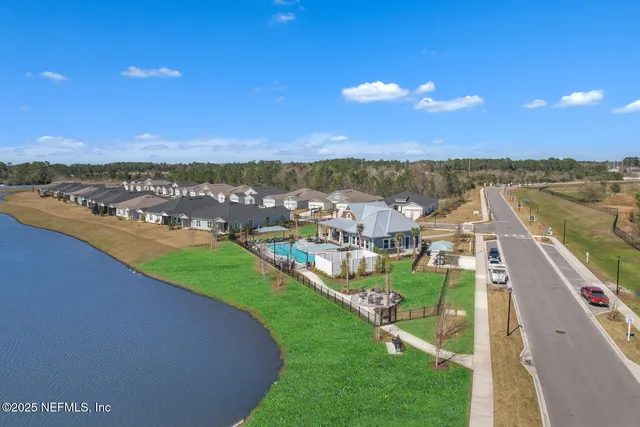 a view of a dining room and livingroom with furniture wooden floor a chandelier