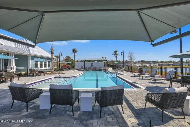 a view of a patio with table and chairs under an umbrella