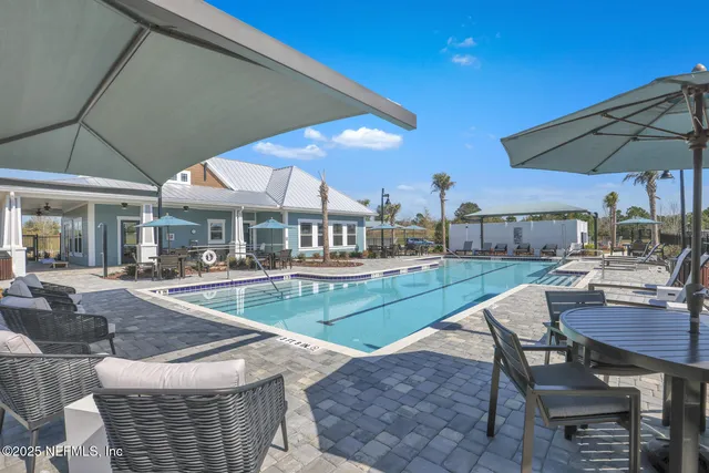 a view of a patio with a table and chairs under an umbrella