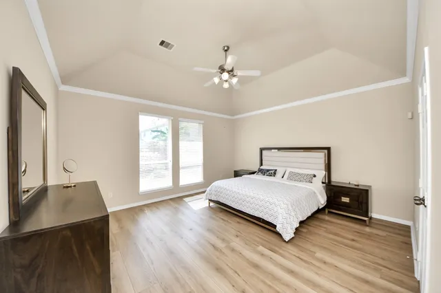a bedroom with a bed window and a night stand