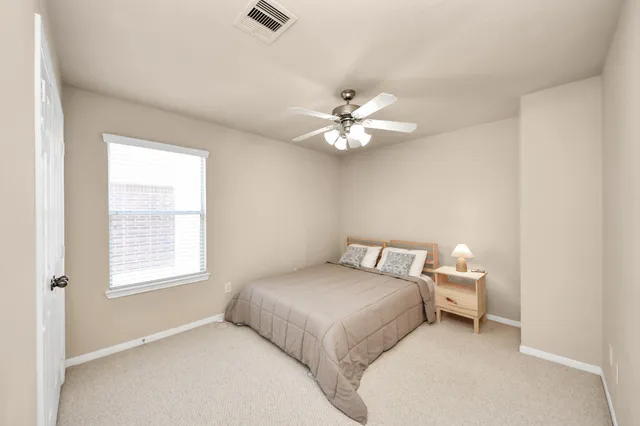 a bedroom with a white bed and a window