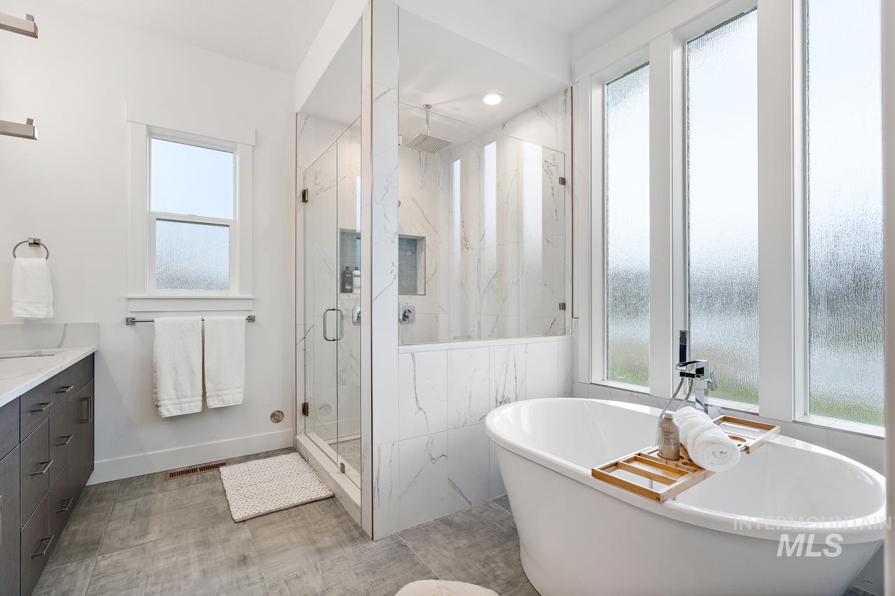 599 West Warren Street Boise, ID 83706 - Photo 21 of 41 Freestanding soaking tub with a floor-mounted faucet, surrounded by multiple privacy windows