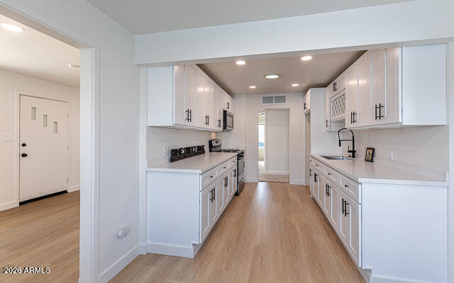 630 Solana Avenue Ajo, AZ 85321 - Photo 20 of 41 a large kitchen with a white stove top oven and white cabinets