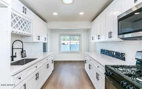 a kitchen with stainless steel appliances granite countertop a sink stove and cabinets