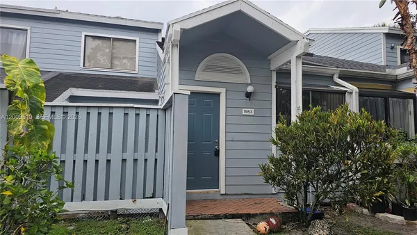 a front view of a house with plants